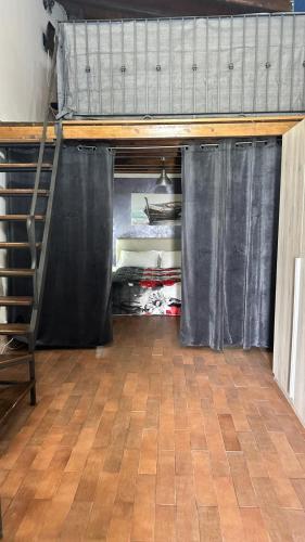 a loft bed with black curtains in a room at Il Rustico in Pozzillo