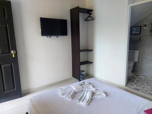 Una habitación con una cama con dos toallas encima. en Casa Coralite, en Santa Marta
