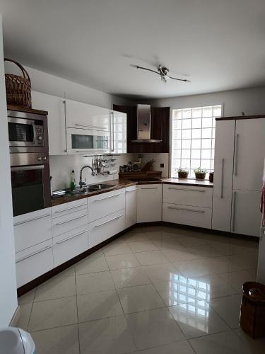 a large kitchen with white cabinets and appliances at Villa Sienna in Smrdan
