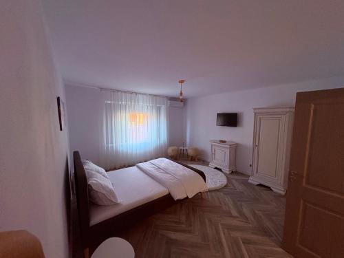 a bedroom with two beds and a window at La Tata Oancea Moldova Veche in Moldova Veche