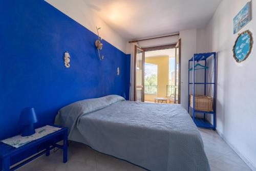 a bedroom with a bed and a blue wall at Villa Laconi in Alghero