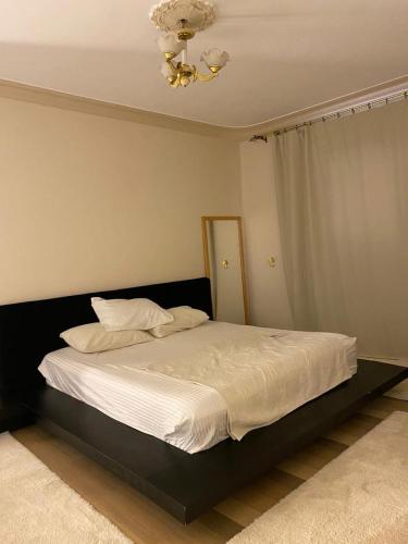 a bedroom with a bed with white sheets and a ceiling at Villa In 5th Settlement in Cairo