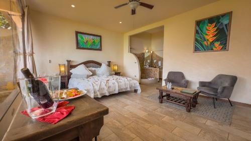 a hotel room with a bed and a table and chairs at Issimo Suites (Adults Only) in Manuel Antonio