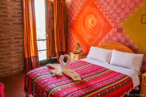 een hotelkamer met een bed met een knuffeldier erop bij OtavaloHuasi2 Quito in Quito