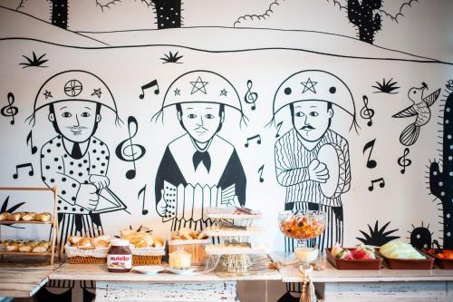 a buffet of food with a mural of chefs at Hotel do Grande Rio in Petrolina