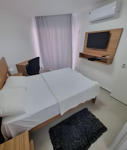 two beds in a room with a tv and a rug at Barra Palace Hotel in Rio de Janeiro
