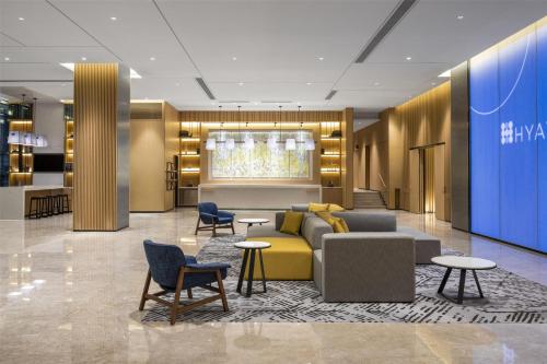 a lobby with a couch and chairs and tables at Hyatt Place New Taipei City Xinzhuang in Xinzhuang