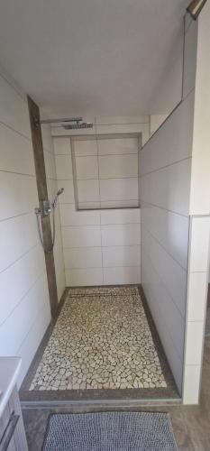 a bathroom with a shower with a stone floor at Ferienwohnung Marga in Kall