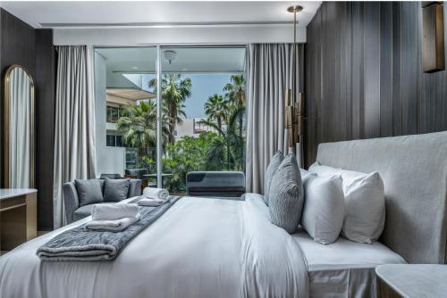 a bedroom with a white bed and a large window at FIVE Palm Jumeirah Premier Apartments in Dubai