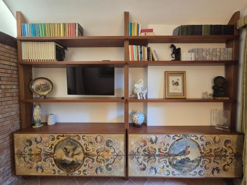 un estante de libros con TV encima en Casa Francesca Apartment, en Taormina