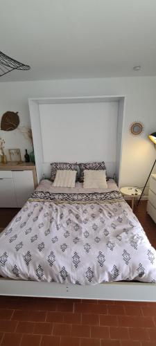 une chambre avec un lit avec une tête de lit blanche dans l'établissement FROMENTINE - VUE MER - STUDIO 2 pers- PLAGE 20 m, à La Barre-de-Monts