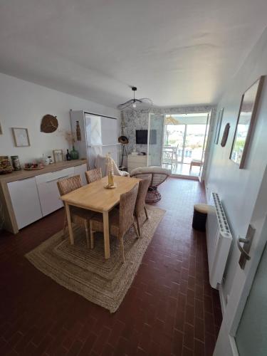 une cuisine et une salle à manger avec une table et des chaises dans l'établissement FROMENTINE - VUE MER - STUDIO 2 pers- PLAGE 20 m, à La Barre-de-Monts