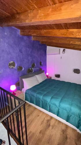 a bedroom with a bed in a room with purple walls at Il Rustico in Pozzillo