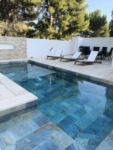- une piscine avec des chaises, une table et un peu d'eau dans l'établissement Villa avec piscine Châtaigniers - Villa 3 pièces 4 personnes MAE-1773, à Rognac