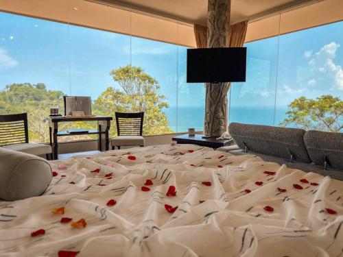 a bedroom with a large bed with roses on it at Issimo Suites (Adults Only) in Manuel Antonio