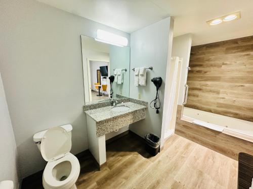 a bathroom with a toilet and a sink and a tub at The Beaverhead Lodge in Dillon
