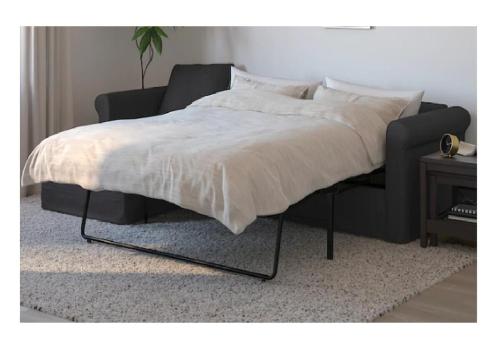 a bed in a bedroom with a black bed frame at City Apartments Soltau in Soltau