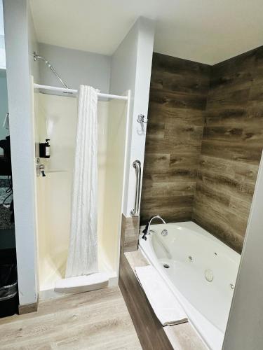 a bathroom with a white tub and a shower at The Beaverhead Lodge in Dillon
