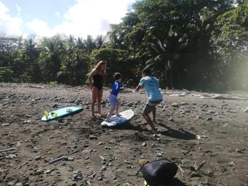 a group of people standing on a beach with surfboards at Casa Cielo in Pavones