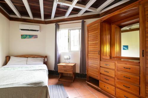 a bedroom with a bed and a dresser and a window at Casa Cielo in Pavones