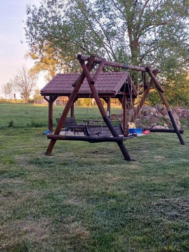 a wooden swing set in a grassy field at Gościniec Twoje Mazury nad jeziorem Śniardwy tuż obok plaży in Nowe Guty
