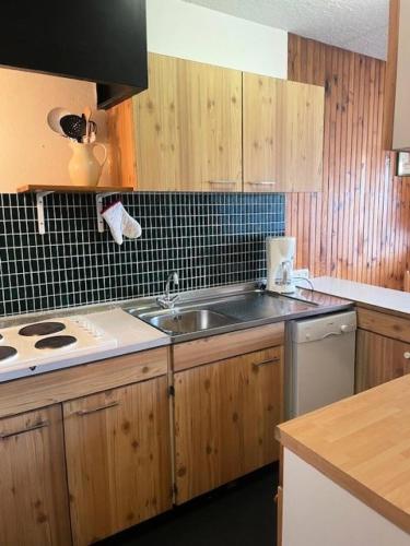 une cuisine avec un évier et une cuisinière dans l'établissement Résidence Queyrelet Ii - 2 pièces cabine 6 personnes MAE-2816, à Orcières