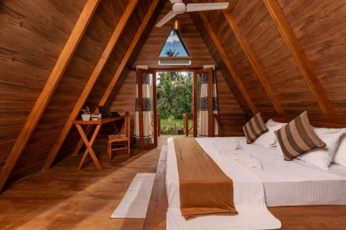 a bed in a room with a ceiling fan at Breeze Over Paddy Field Cabana in Unawatuna