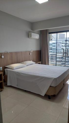 a large bed in a bedroom with a window at Happy Hotel Garvey Park in Brasília