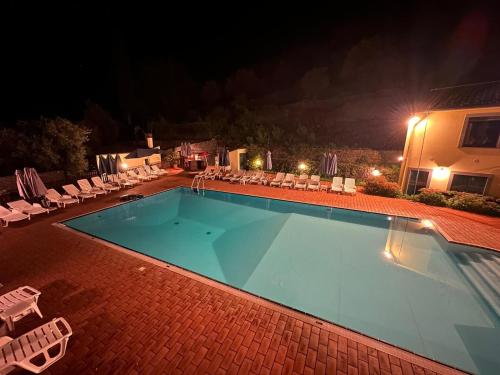 a swimming pool at night with lounge chairs at L'Antica Vigna in Randazzo