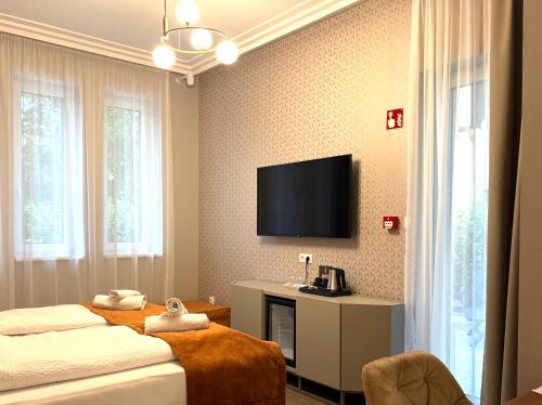 a hotel room with two beds and a flat screen tv at Annie Villa in Siófok