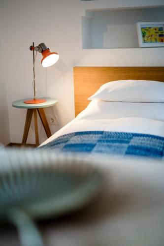 a bedroom with a bed and a table with a lamp at Das Esel - Kleinod in Rust in Rust