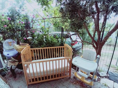 a crib and chairs sitting next to a fence at Zagradge IN Apartments in Zagrađe
