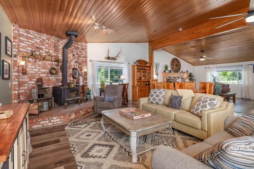 una sala de estar con una pared de ladrillo en Yosemite Creekside Retreat with spa/games/EV Charger and more, en Yosemite Forks