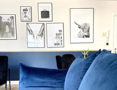 - une chambre dotée d'un lit bleu avec des photos sur le mur dans l'établissement Flanelles - beautiful apartment Lyon 8, à Vénissieux