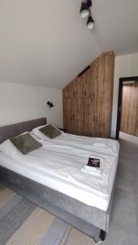a bedroom with a large bed with a wooden headboard at Nowa Osada in Łącko