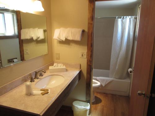 een badkamer met een wastafel, een toilet en een douche bij Al's Westward Ho Motel in West Yellowstone
