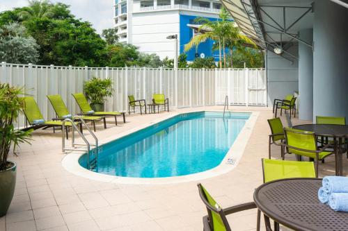 a pool with tables and chairs next to a building at SpringHill Suites Miami Downtown/Medical Center in Miami