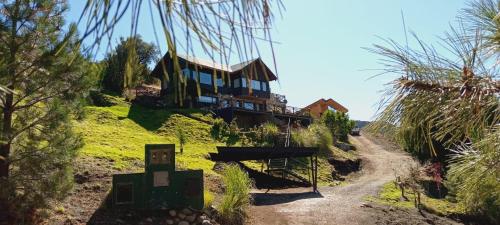 ein Haus auf einem Hügel mit einer unbefestigten Straße in der Unterkunft Casa Patagonia in San Martín de los Andes