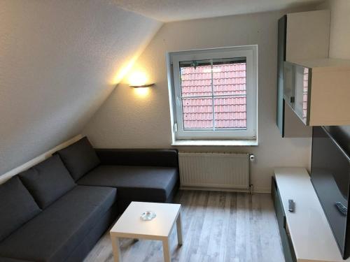 a small living room with a couch and a table at ruhige aber zentral gelegene Ferienwohnung im Obergeschoss in Dornum