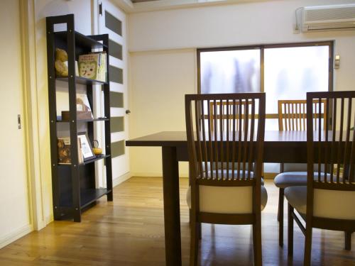 una sala da pranzo con tavolo e sedie di Guesthouse Ten-roku - Female Only ad Osaka