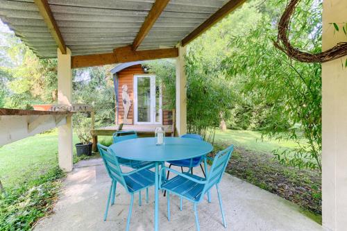 a blue table and chairs on a patio at La Roulotte à 10min de Disneyland Paris - Cabane & Cabanon in Chalifert
