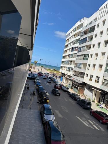 a street with parked cars and a large building at Joli Studio with Seaview 16 in Casablanca