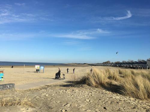 a group of people walking on the beach at freistehendes Ferienhaus mit Sauna und Kamin in Kamperland