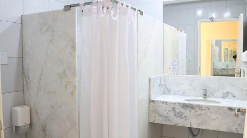 a bathroom with a shower curtain and a sink at Hotel do Grande Rio in Petrolina