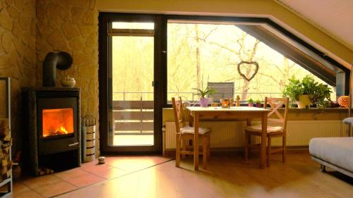 a living room with a table and a fireplace at Gemütliches Appartement In Ottenhai Mit Grill in Bad Harzburg