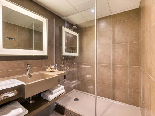 a bathroom with a sink and a shower at Novotel Paris Nord Expo Aulnay in Aulnay-sous-Bois
