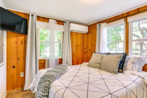 a bedroom with a large bed and two windows at All-Season Vernon Township Lake House Retreat! in Vernon Township