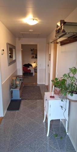 a hallway with a living room with a table and a bedroom at Stort og dejligt værelse med privat bad in Hornsyld