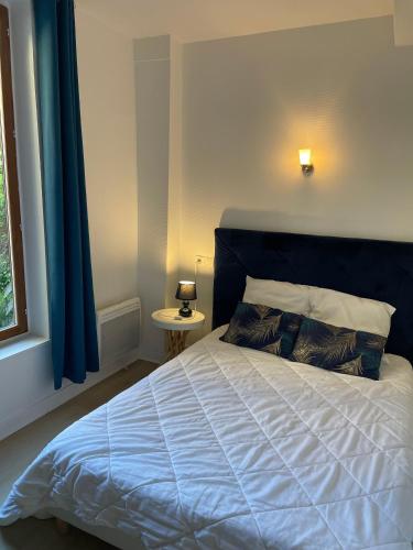 - une chambre avec un lit doté d'une tête de lit bleue et d'une fenêtre dans l'établissement Escapade en Champagne, à Troyes