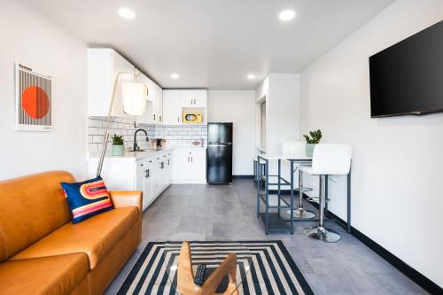 a living room with a couch and a kitchen at Heights House Hotel - Houston Heights Downtown, an Ascend Collection Hotel in Houston